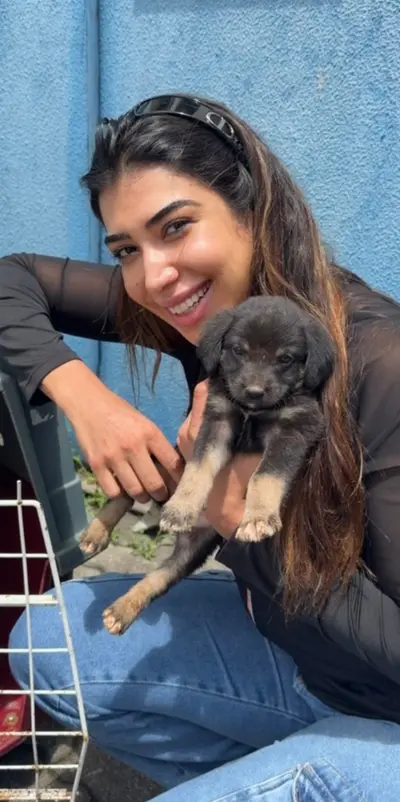 Mulher acolhendo um filhote de cachorro nos braços